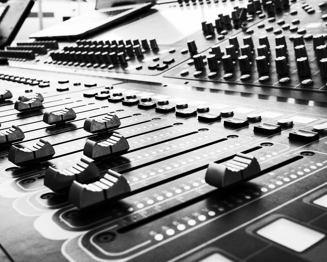 Faders y potenciómetros de una mesa de mezclas de estudio vistos de cerca